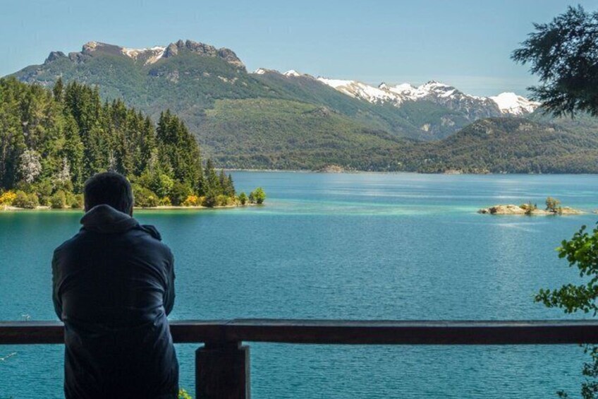 A person overlooking a lake with mountains in the background. 1
