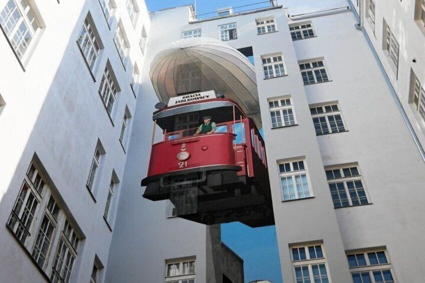 A red cable car suspended between two white buildings. 1