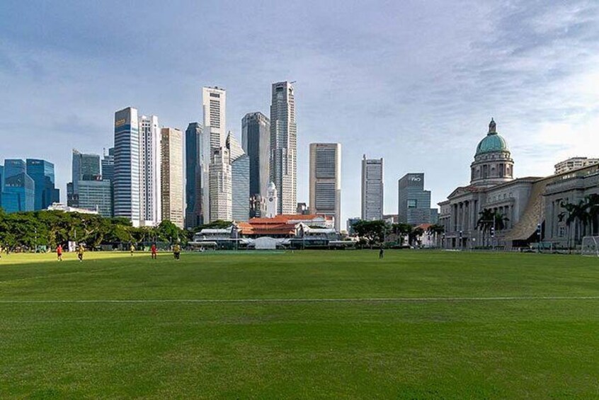A city skyline with modern skyscrapers, a large open grassy area, and a historic building with a dome. 2