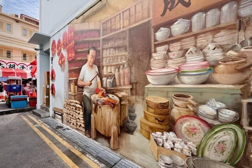 A street scene with a mural of a person playing a traditional instrument, surrounded by pottery and ceramics. 4