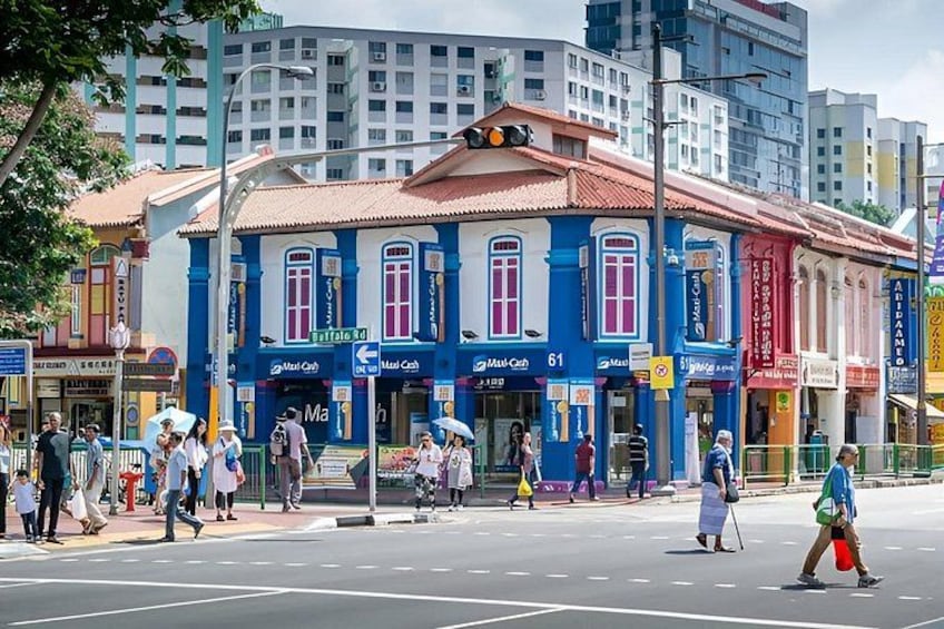 A street with colorful buildings, pedestrians, and a crosswalk. 2