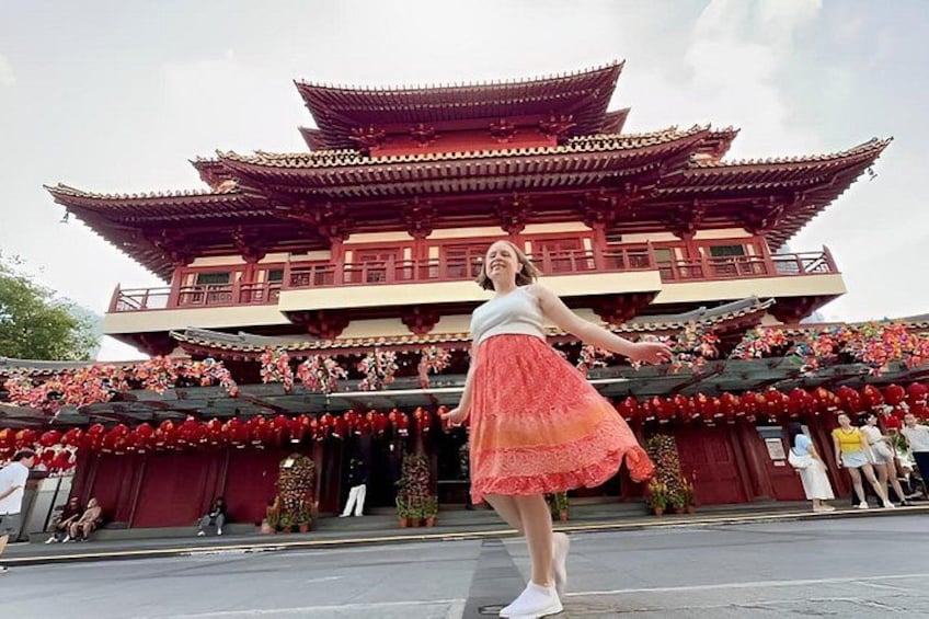 A traditional red and white building with multiple tiers and a person in a red skirt standing in front. 4