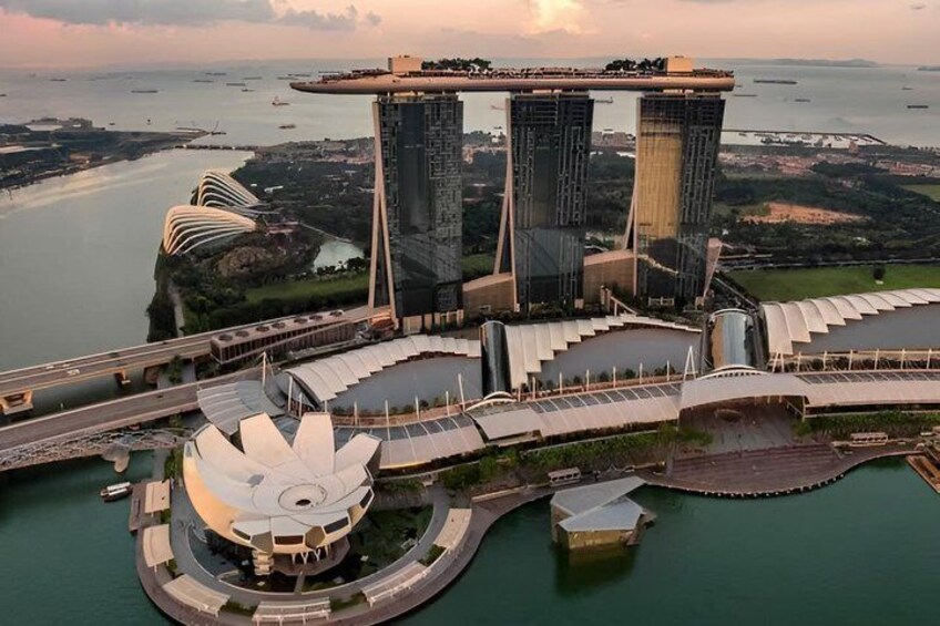A large waterfront structure with a distinctive curved roof, a tall central tower, and a circular building with a lotus-like design. 3
