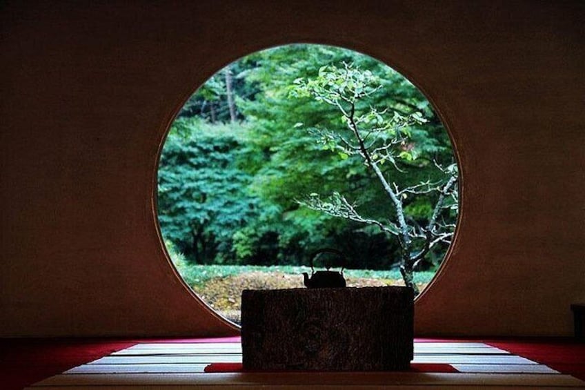 A circular window with a view of a tree and a forest. 4