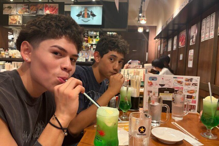 Two people sitting at a table in a restaurant with drinks and menus. 4