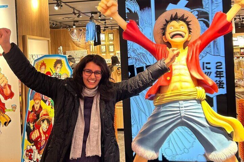 A person standing in front of a large One Piece statue. 1