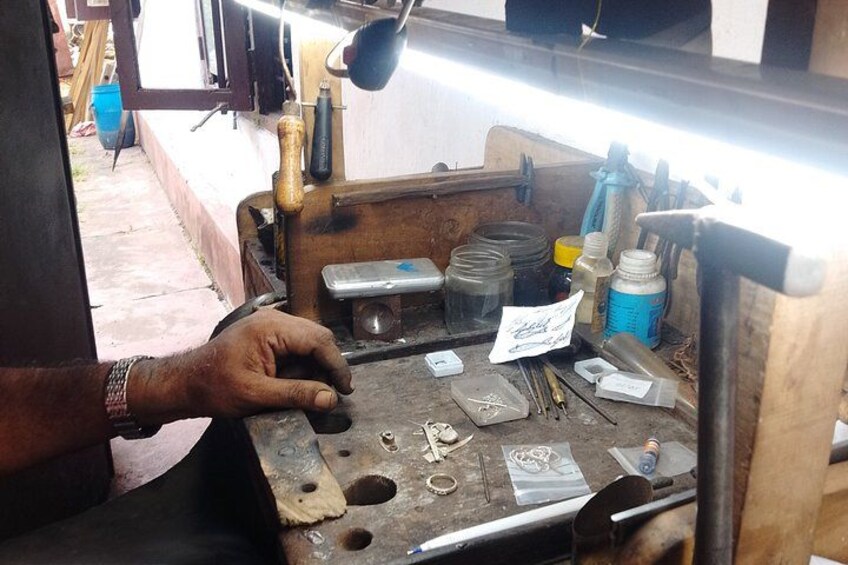 A person working on a mechanical device with tools and parts on a workbench. 3
