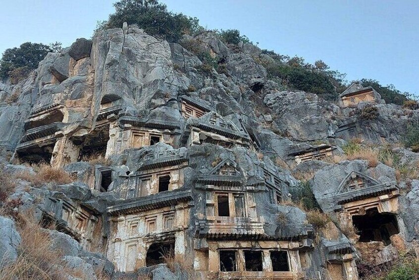 Ancient rock-cut architecture with multiple structures carved into the hillside. 3