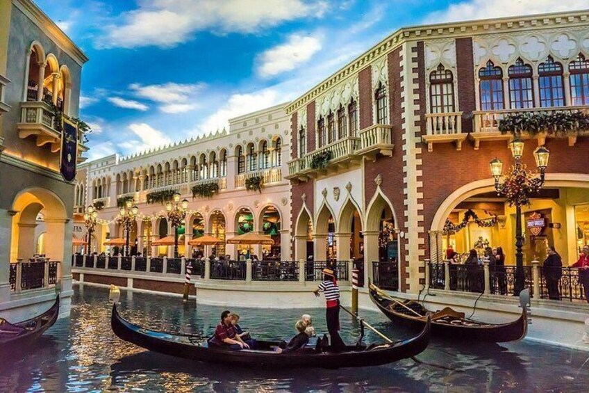 A canal with gondolas, a building with arched windows, and a clear sky. 3