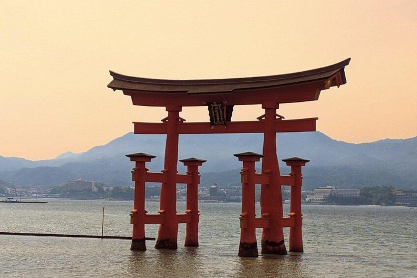 A traditional Japanese torii gate in the water with mountains in the background. 1