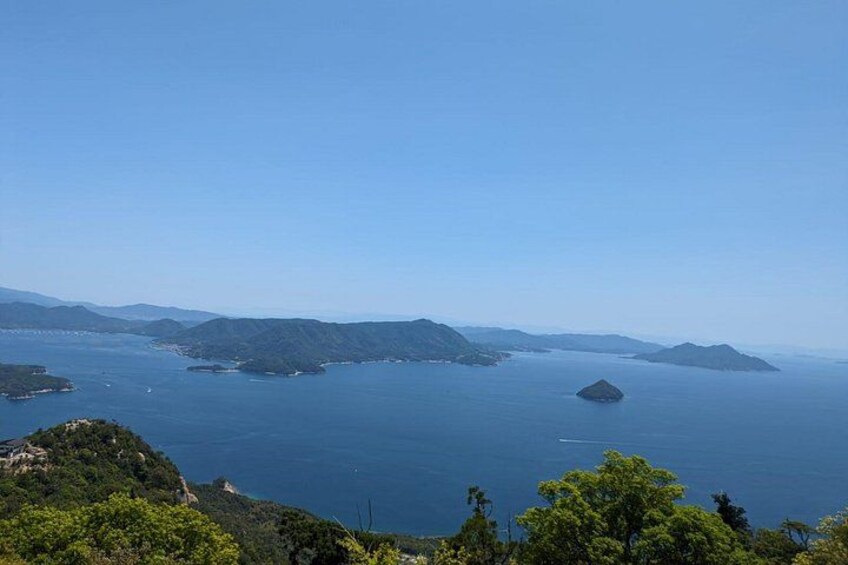 A coastal landscape with a clear sky, a large body of water, and several islands. 3
