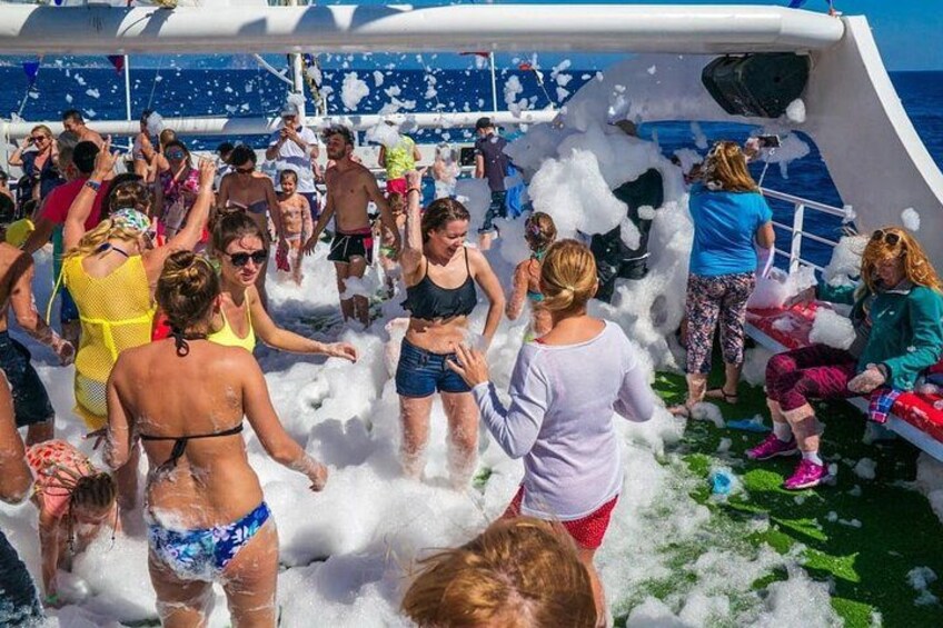 People on a boat with foam and water splashing around. 4