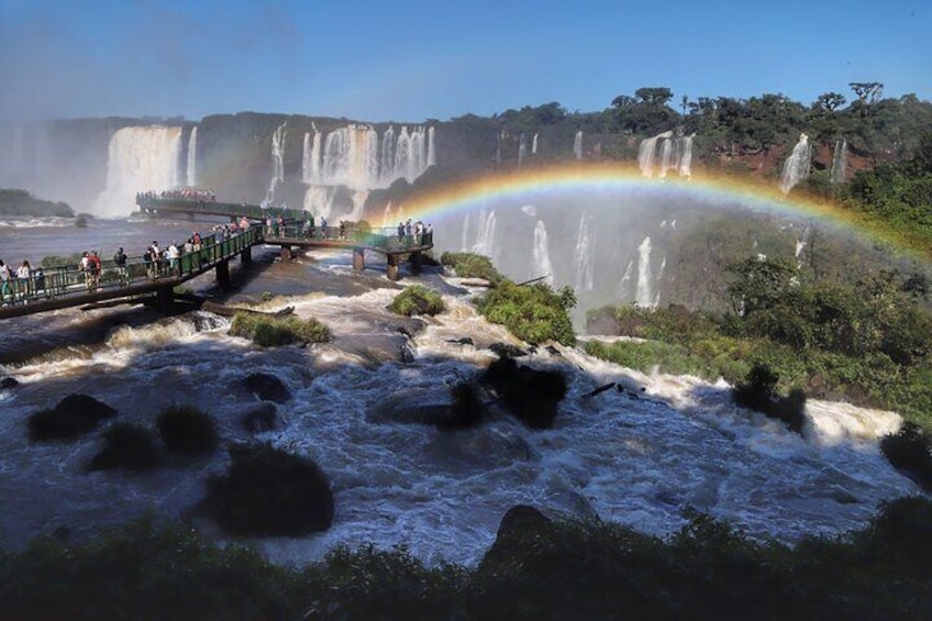 A waterfall with a rainbow, a viewing platform, and a bridge. 3