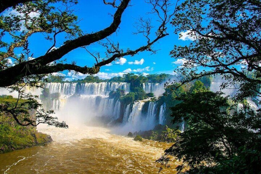 A waterfall cascading over a river surrounded by lush greenery. 1