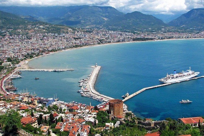 A coastal city with a large bay, a pier, and a cruise ship docked. 1