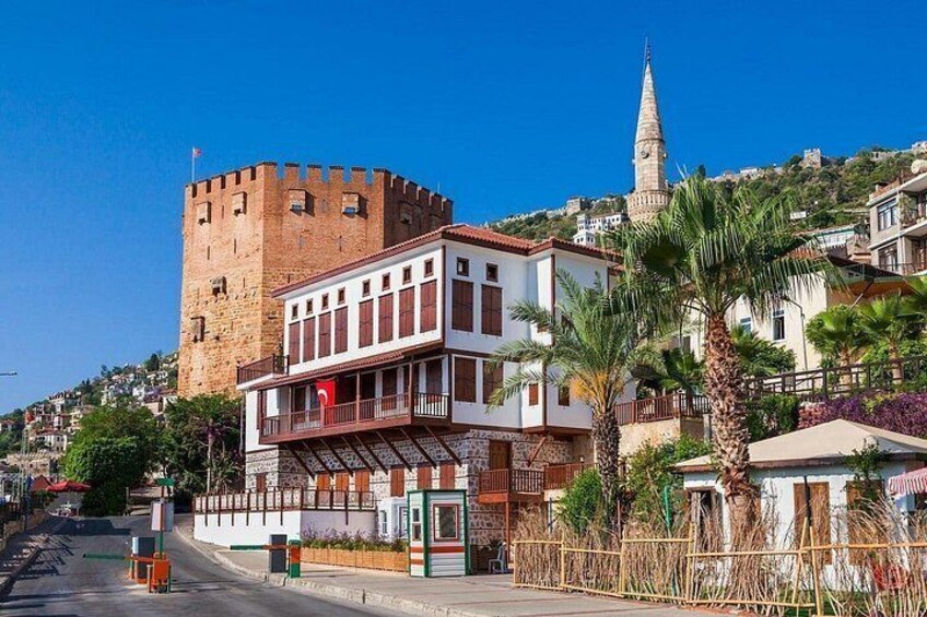 A historic town with a prominent castle, a church spire, and a modern building with balconies. 2