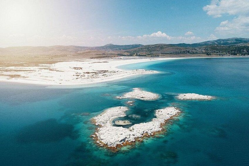 A coastal landscape with clear turquoise waters, sandy beaches, and white sandbars. 2