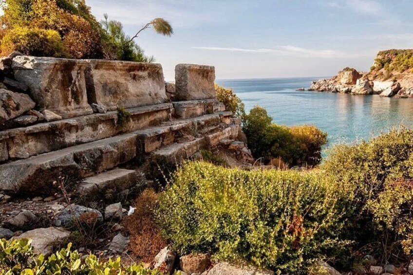 Ancient stone steps leading to a cliff overlooking a calm sea. 2