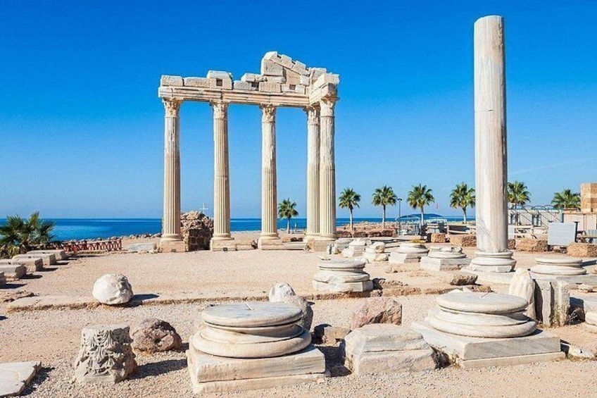 Ancient ruins with columns and stone structures by the sea. 4