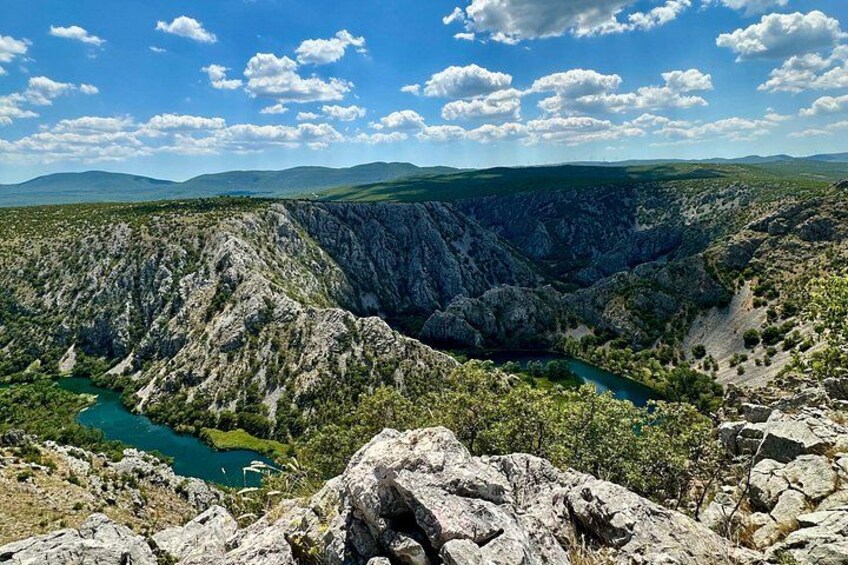 A mountainous landscape with a river, rocky terrain, and a clear sky. 5