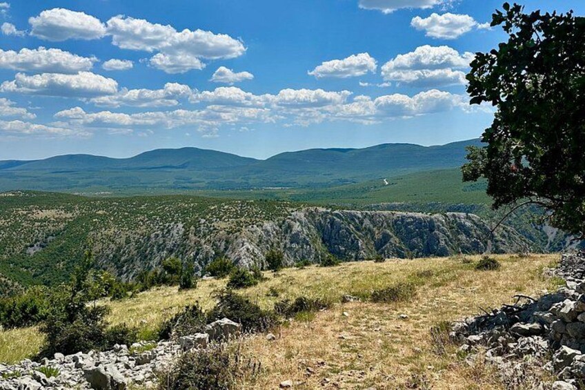 A mountainous landscape with a clear sky and scattered clouds. 4