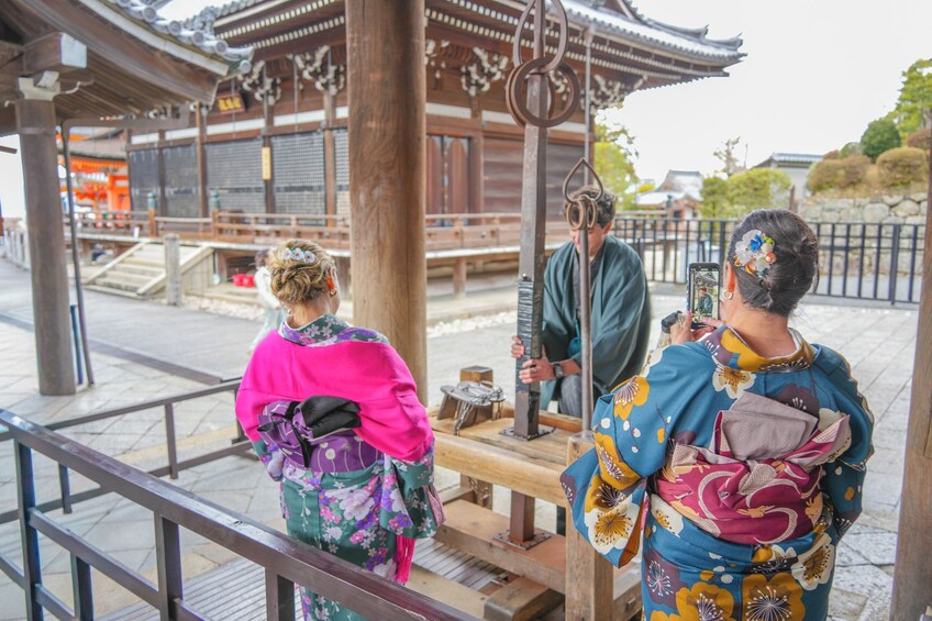 Un entorno tradicional japonés con estructuras de madera y personas vestidas con kimonos. 4