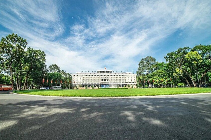 A large building with a symmetrical facade, surrounded by a well-maintained lawn and trees. 3