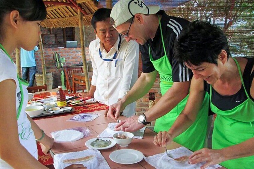People preparing food at a table with bowls and plates. 5
