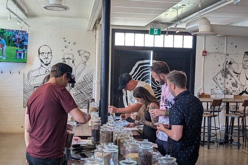 A group of people at a food station with jars of condiments. 4