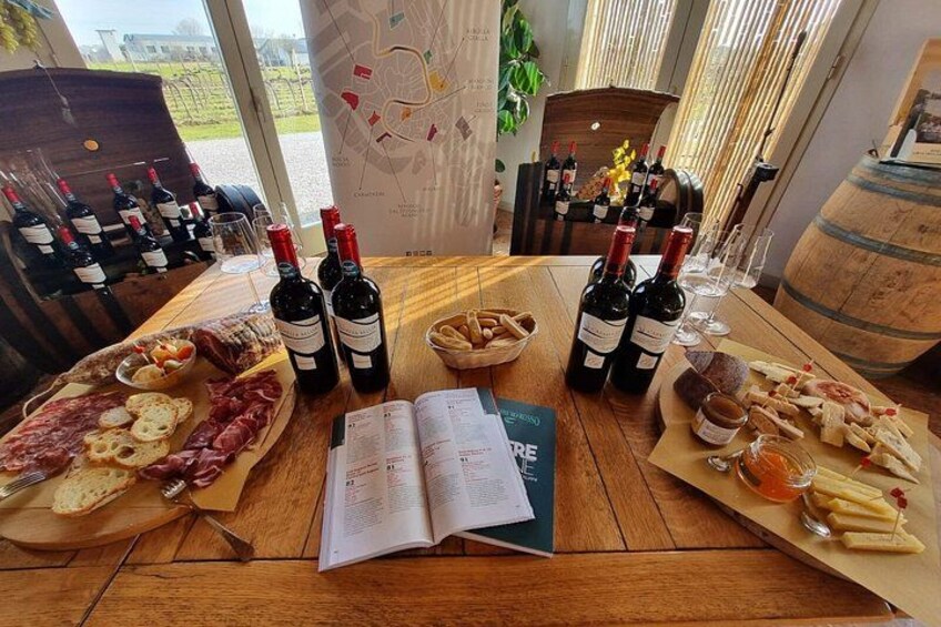 A wooden table with wine bottles, glasses, and charcuterie boards. 1