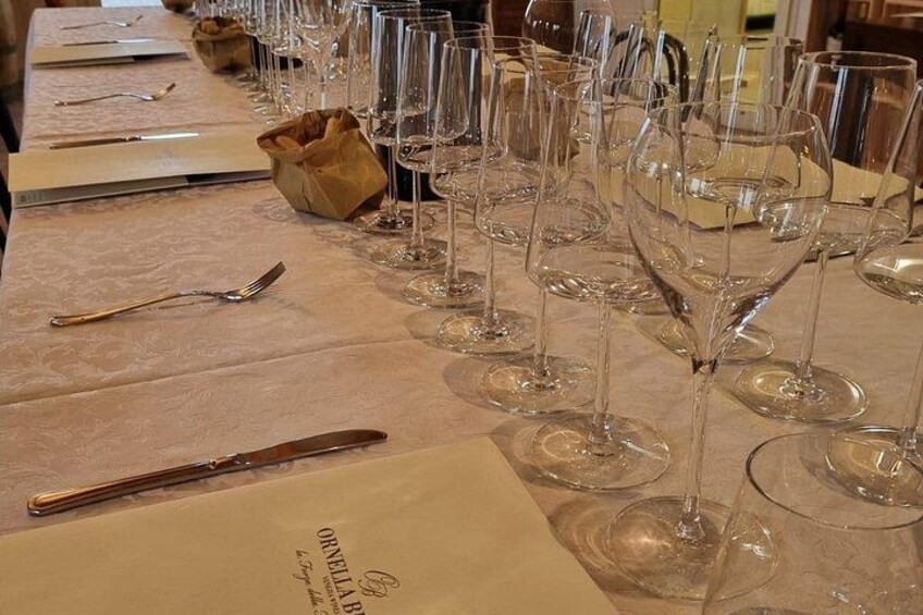 A table set with wine glasses, cutlery, and menus. 2