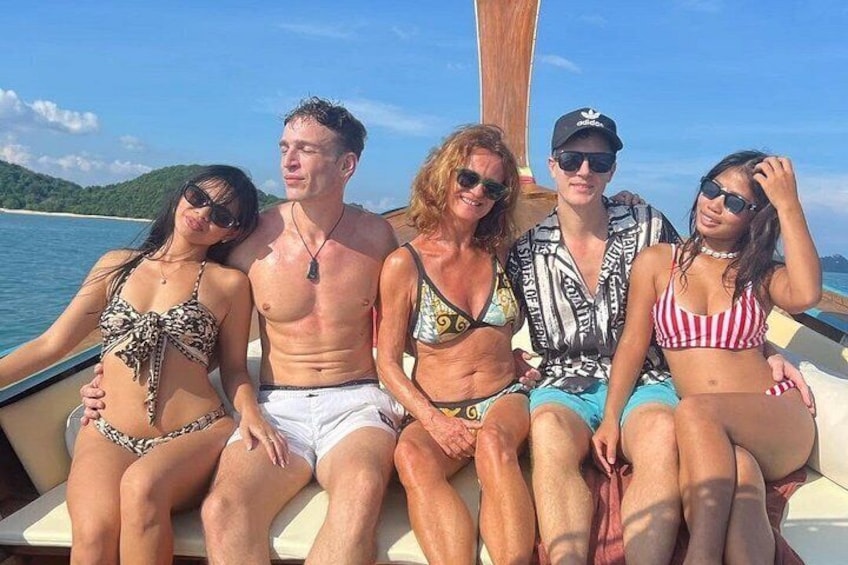 A group of people on a boat with a clear sky and water in the background. 1