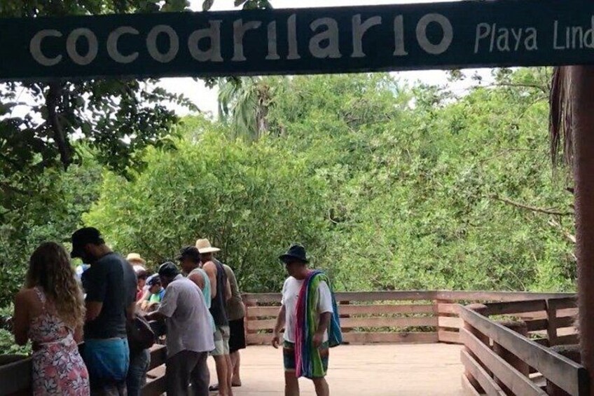 A wooden bridge with a sign reading 'cocodrillo Playa Lind.' 4