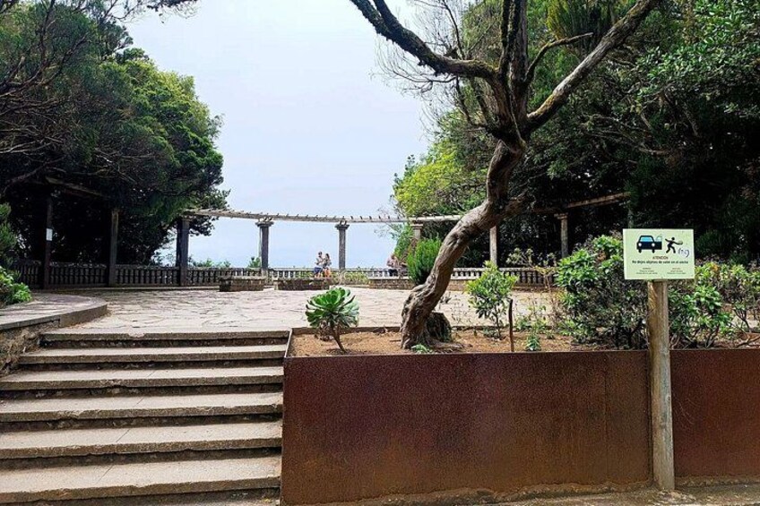 A park with a bridge, steps, and a sign indicating a parking area. 2