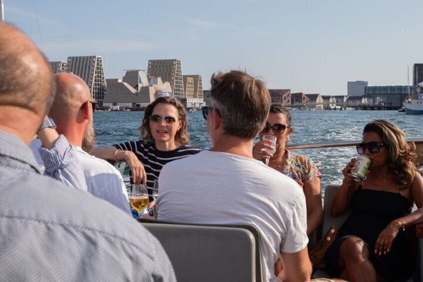 A group of people on a boat with a city skyline in the background. 4