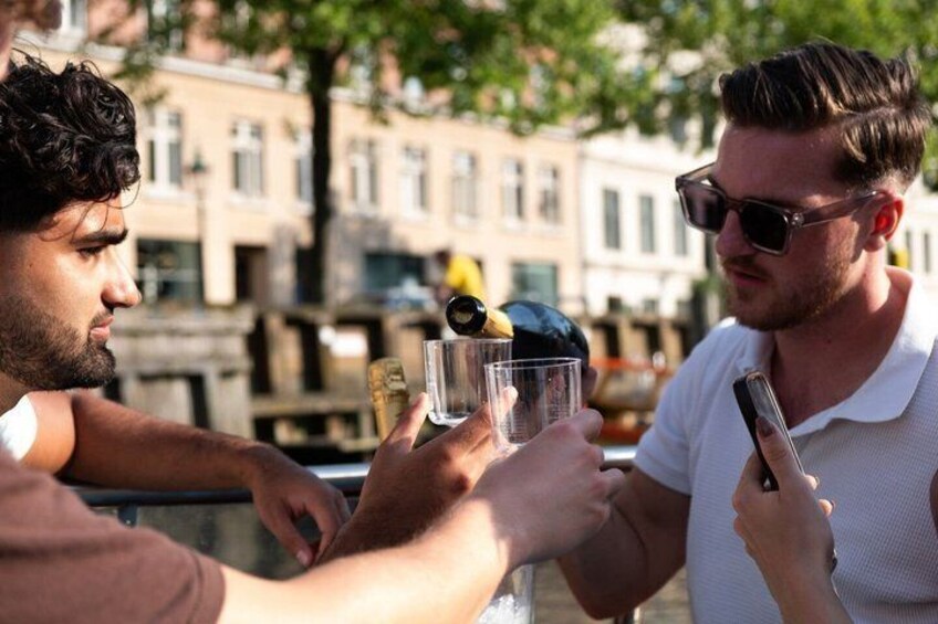 Two people toasting with drinks, one holding a smartphone. 1