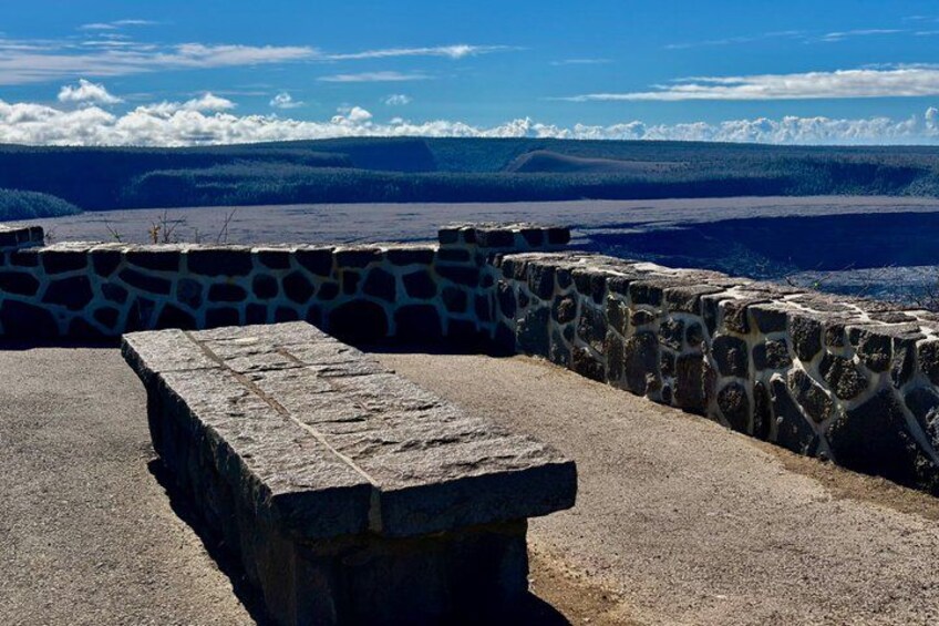 A stone bench overlooking a scenic landscape with a stone wall and a view of distant mountains. 4