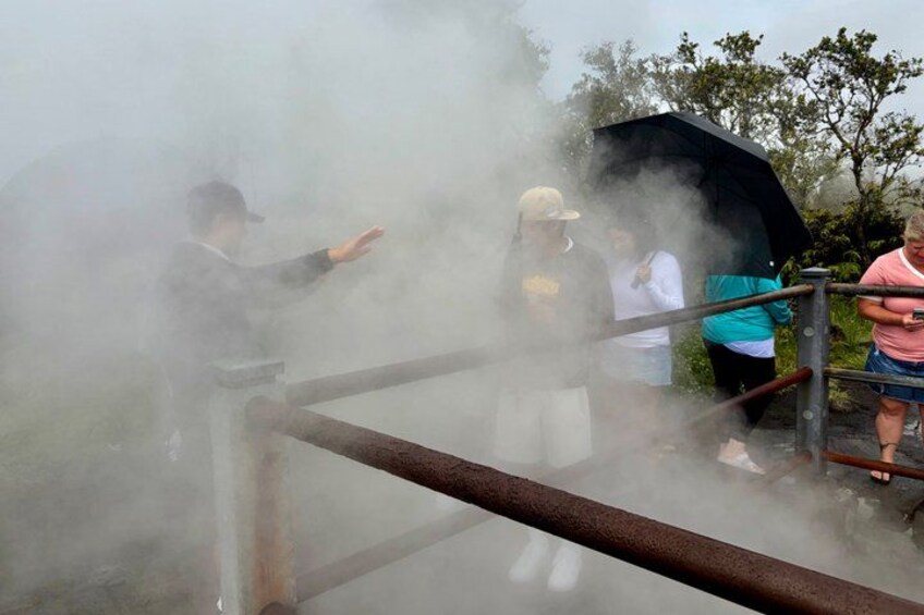 A person releasing steam from a device, with others observing. 5