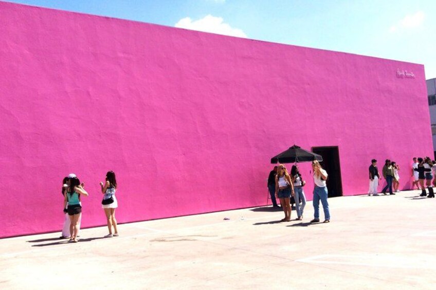 A pink building with people standing in front of it. 4