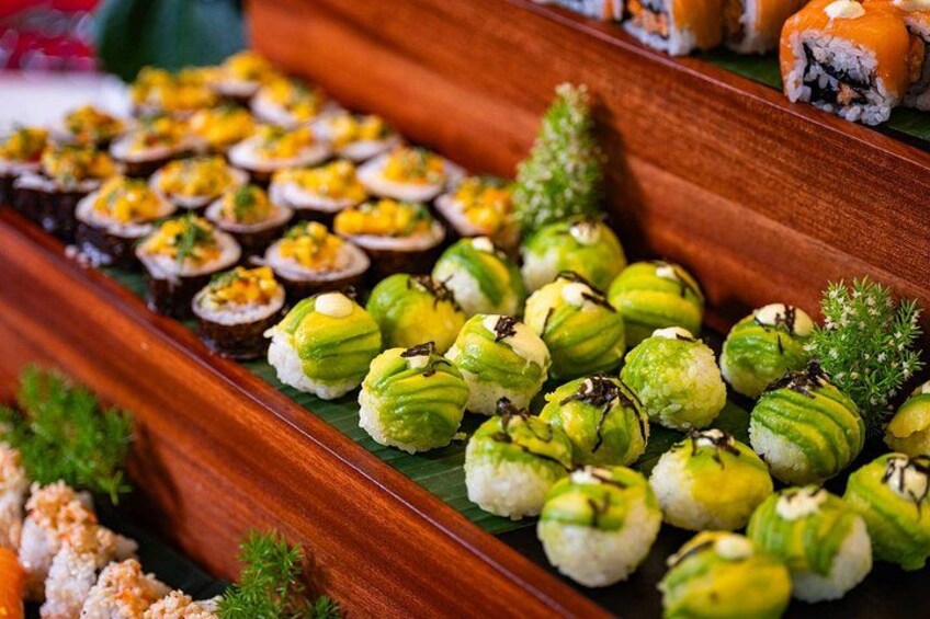Variedad de sushi y otros platos japoneses expuestos en bandejas de madera. 5
