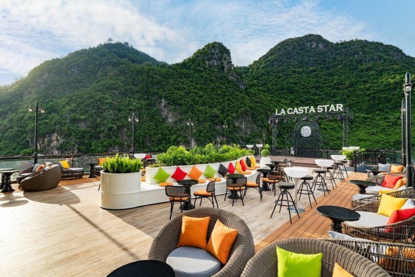 Un bar en la azotea con mesas al aire libre, un paisaje de montañas al fondo y el nombre 'LA CASTA STAR' a la vista. 4