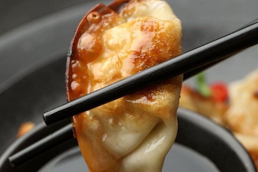 A close-up of a food item being held with chopsticks. 5