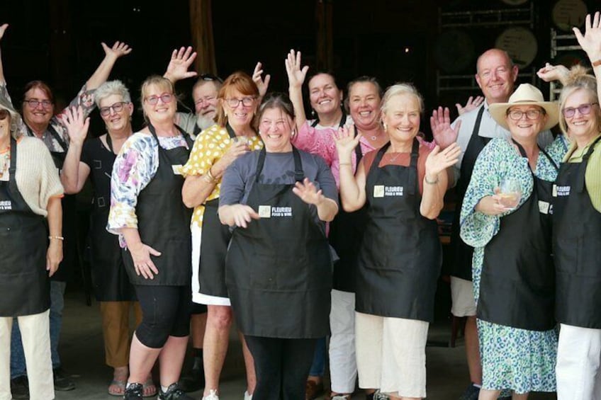 A group of people wearing aprons with 'FLAVOUR' on them, standing together. 1