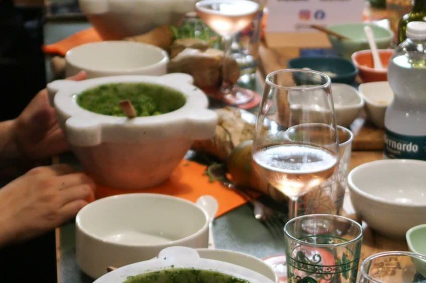 A table with various dishes, including a bowl with a green sauce and a glass of water. 3