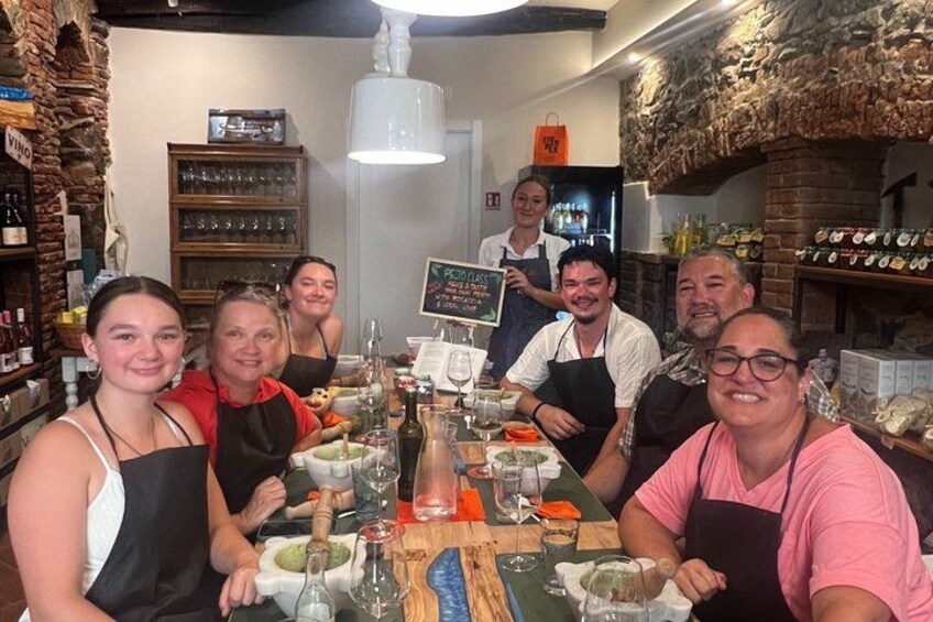 A group of people seated around a table with food and drinks, in a restaurant with a rustic interior. 3