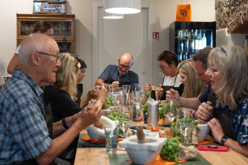 A group of people sitting around a table with food and drinks, engaged in conversation. 1