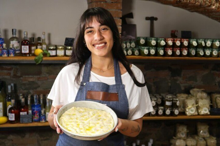 A person holding a bowl of food, with shelves of bottles and jars in the background. 5
