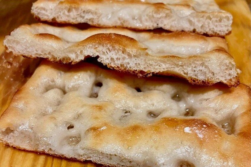 Fette di pane focaccia con crosta dorata e olio d'oliva visibile. 2