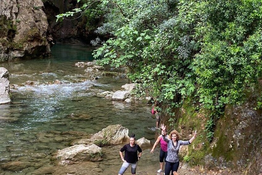 A river with clear water, rocky banks, and lush greenery. 2
