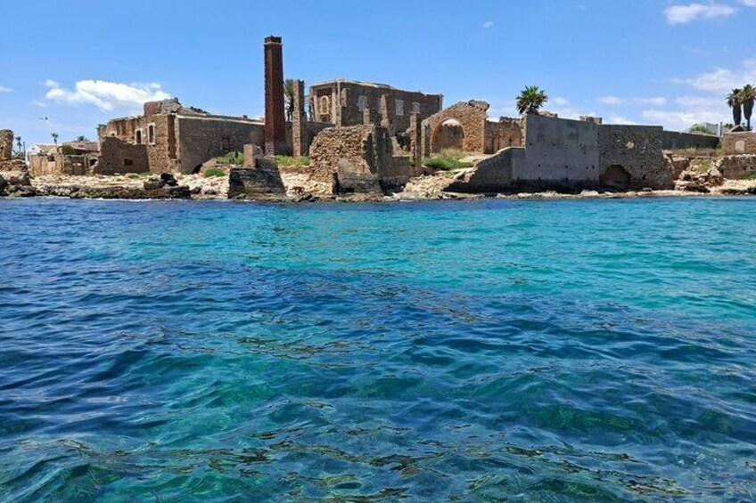 A coastal historical site with ruins and clear blue waters. 2